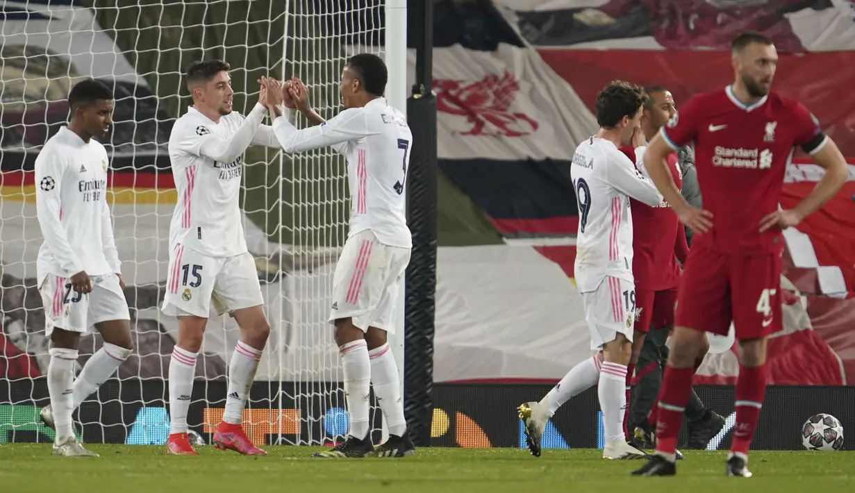 Pemain Real Madrid, Federico Valverde (kiri) dan Eder Militao merayakan selebrasi usai pertandingan melawan Liverpool pada leg kedua babak perempat final Liga Champions di stadion Anfield di Liverpool, Inggris, Kamis (14/4/2021). Liverpool bermain imbang atas Madrid 0-0. (AP Photo/Jon Super)