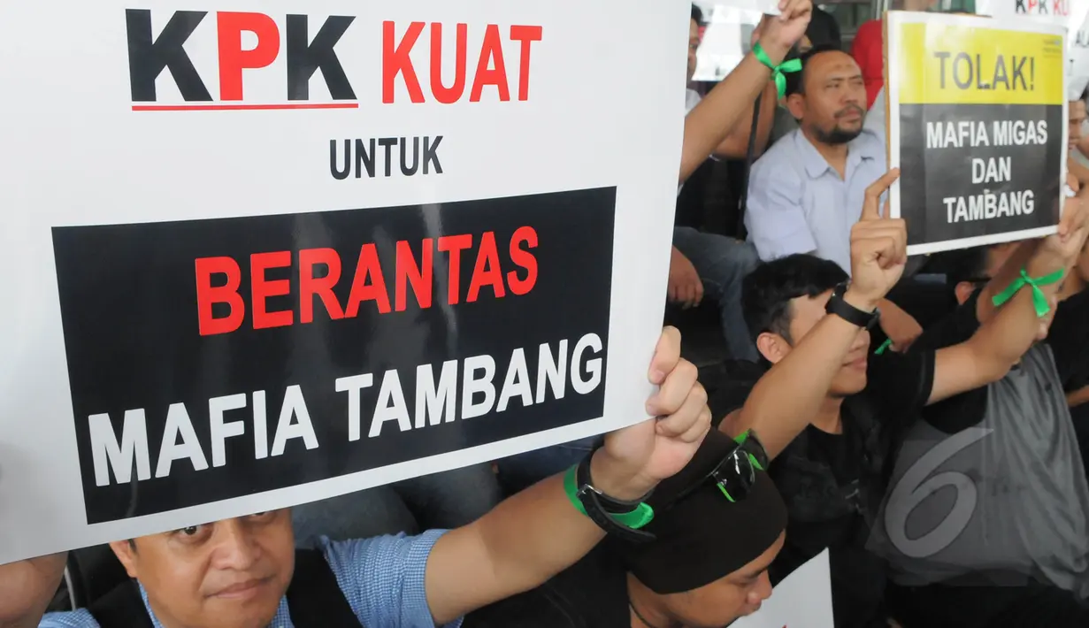 Seorang aktivis membentangkan poster saat menggelar aksi di halaman gedung KPK, Jakarta, Jumat (13/3/2015). Mereka menolak kriminalisasi KPK yang selama ini konsisten memberantas korupsi khususnya disektor sumber daya alam. (Liputan6.com/Herman Zakharia)