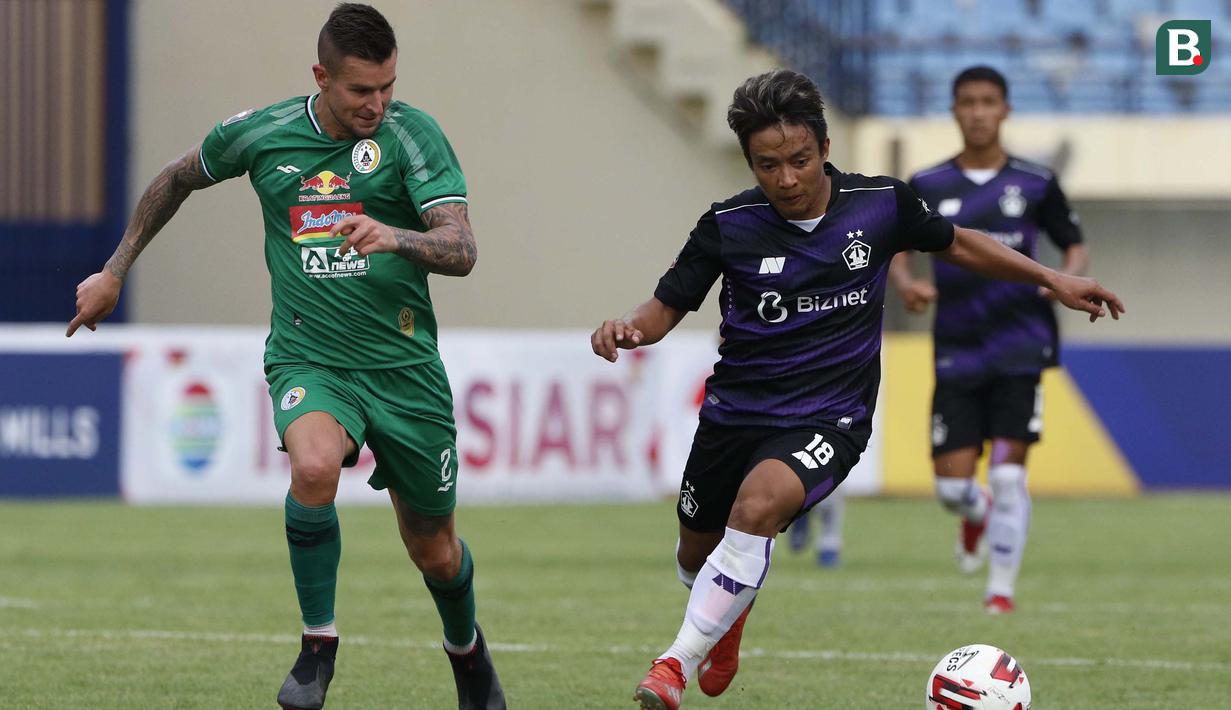 Striker Persik Kediri, Hariyanto S Panto (kanan) dijaga ketat bek PS Sleman, Aaron Michael Evans dalam laga matchday ke-3 Grup C Piala Menpora 2021 di Stadion Si Jalak Harupat, Bandung, Kamis (1/4/2021). Persik Kediri kalah 0-1 dari PS Sleman. (Bola.com/Ikhwan Yanuar)