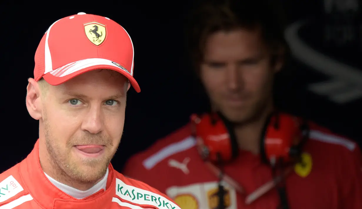 Pebalap Ferrari, Sebastian Vettel tersenyum setelah berhasil meraih meraih posisi start terdepan atau pole position saat sesi kualifikasi F1 GP di Sirkuit Hockenheim, Jerman, Sabtu (21/7). (AP Photo/Jens Meyer)