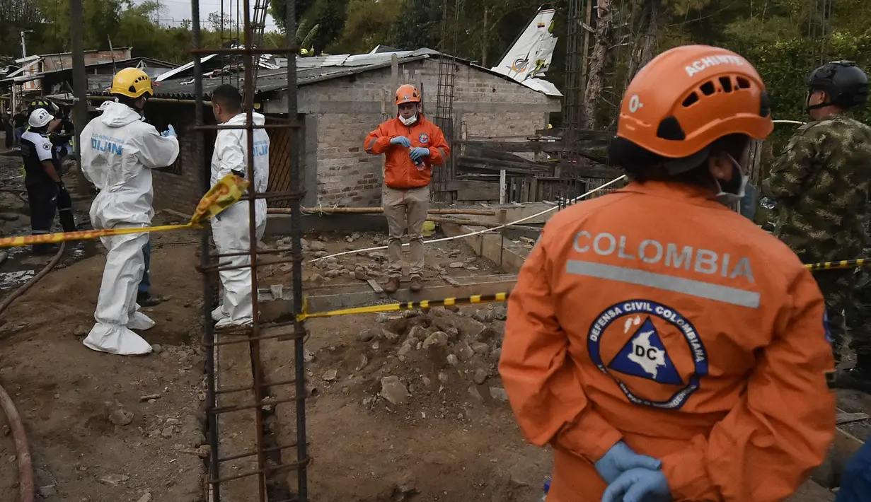 Tim penyelamat berada di lokasi jatuhnya sebuah pesawat kecil di tengah-tengah rumah penduduk di Popayan, Kolombia, Minggu (15/9/2019). Pemadam kebakaran mengatakan tiga orang luka parah, salah satunya adalah seorang anak yang merupakan warga setempat. (Luis ROBAYO / AFP)