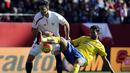 Bek Sevilla, Adil Rami, berebut bola dengan penyerang Las Palmas, Willian Jose, pada laga La Liga di Stadion Roman Sanchez Pizjuan, Spanyol, Minggu (14/2/2016). Sevilla berhasil menaklukan Las Palmas 2-0. (AFP/Cristina Quicler)