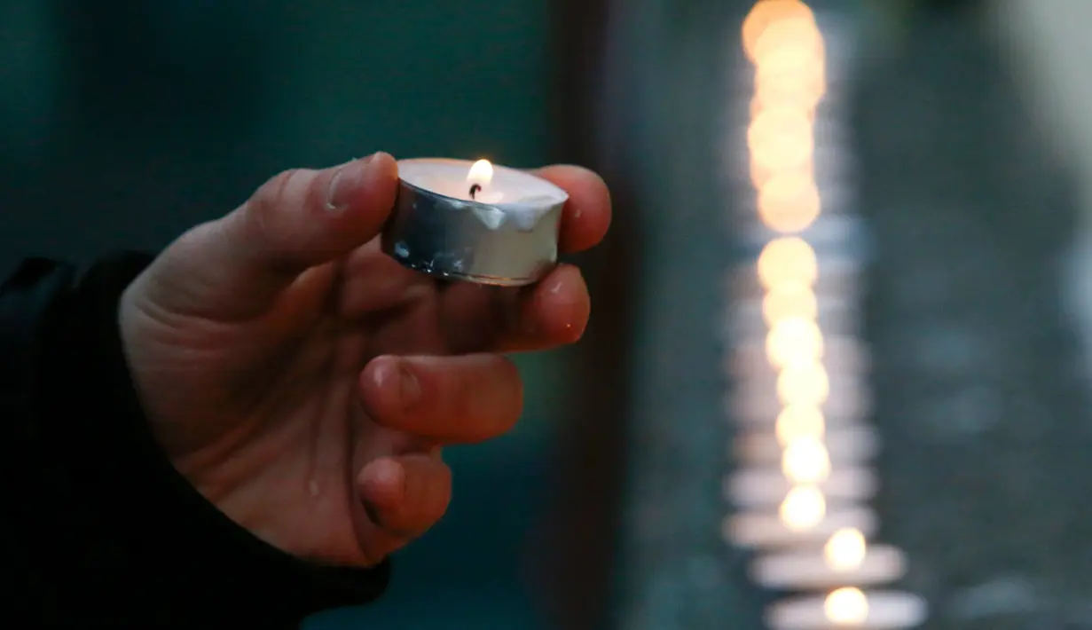 Seorang pria menyalakan lilin sebagai ungkapan berkabung untuk korban dari pesawat militer Rusia Tupolev Tu-154 yang jatuh di Laut Hitam, Rusia, Minggu (25/12). Diperkirakan sebanyak 91 orang belum diketahui nasibnya. (REUTERS / Sergei Karpukhin)