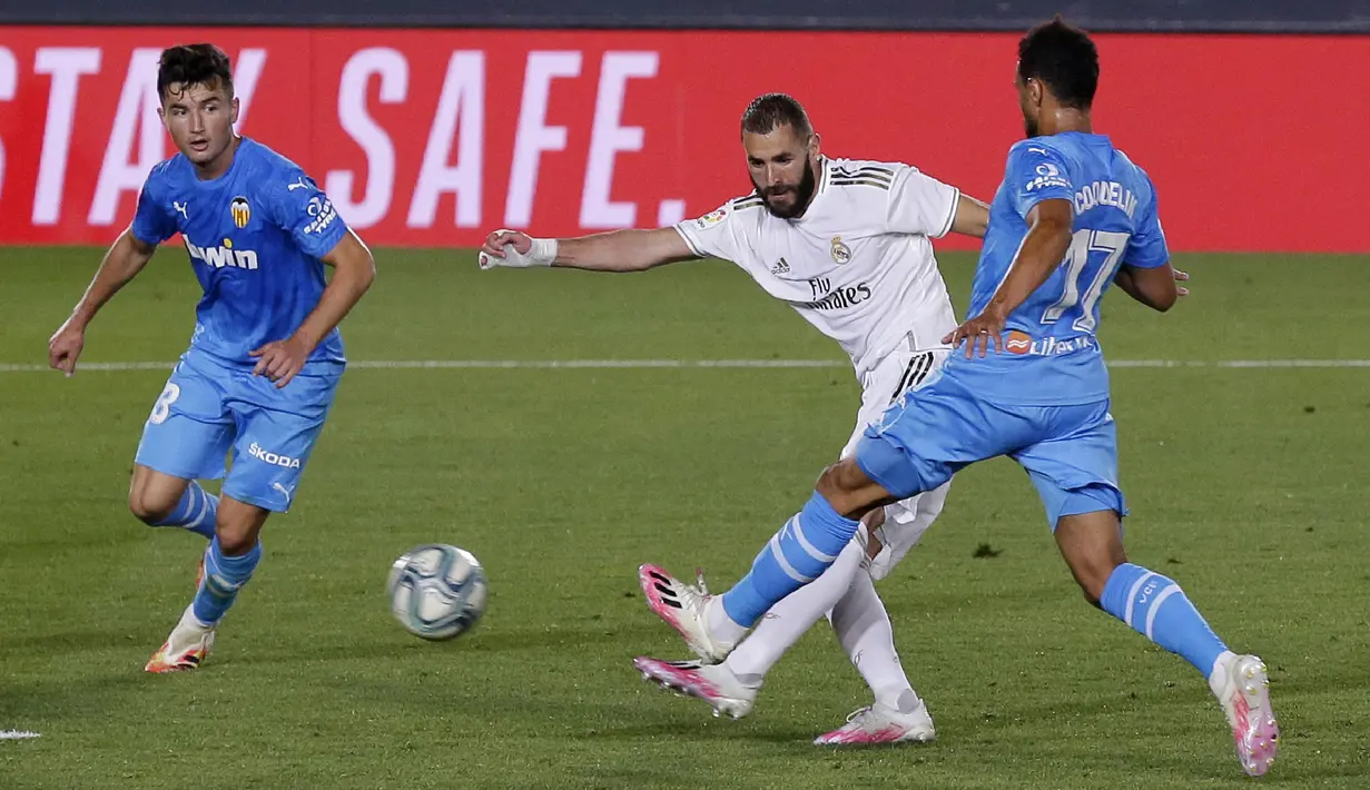Pemain Real Madrid Karim Benzema (tengah) mencetak gol ke gawang Valencia pada pertandingan La Liga Spanyol di Estadio Alfredo Di Stefano, Madrid, Spanyol, Kamis (18/6/2020). Real Madrid menang 3-0 lewat dua gol Karim Benzema dan satu gol Marco Asensio. (AP Photo Manu Fernandez)