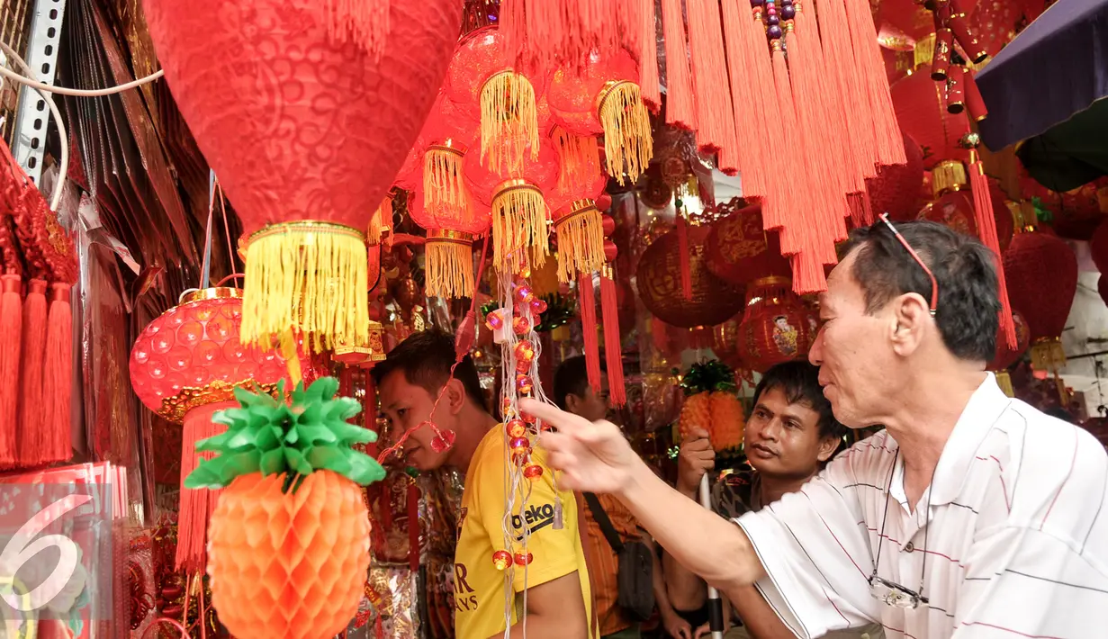 Calon pembeli memilih aksesoris Imlek di kawasan Petak Sembilan, Jakarta, Senin (23/1). Jelang hari raya Imlek 2017 pedagang angpao dan pernak-pernik mulai ramai di kawasan Petak Sembilan. (Liputan6.com/Yoppy Renato)
