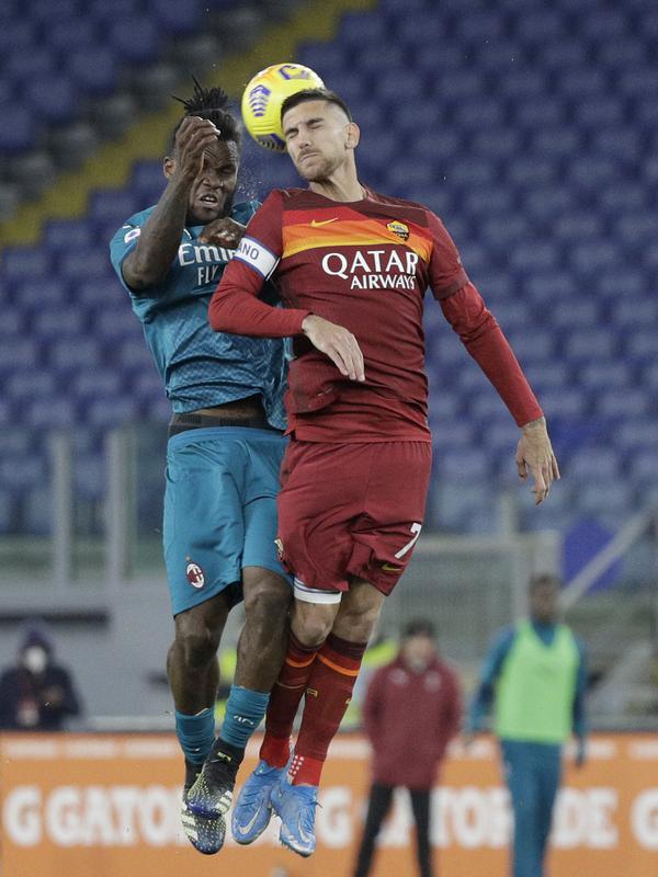 Gelandang AC Milan, Franck Kessie berebut bola dengan gelandang AS Roma, Lorenzo Pellegrini pada pertandingan lanjutan Liga Serie A Italia di stadion Olimpiade, di Roma, Italia,Senin (1/3/2021). AC Milan menang tipis atas AS Roma 2-1. (AP Photo/Gregorio Borgia)