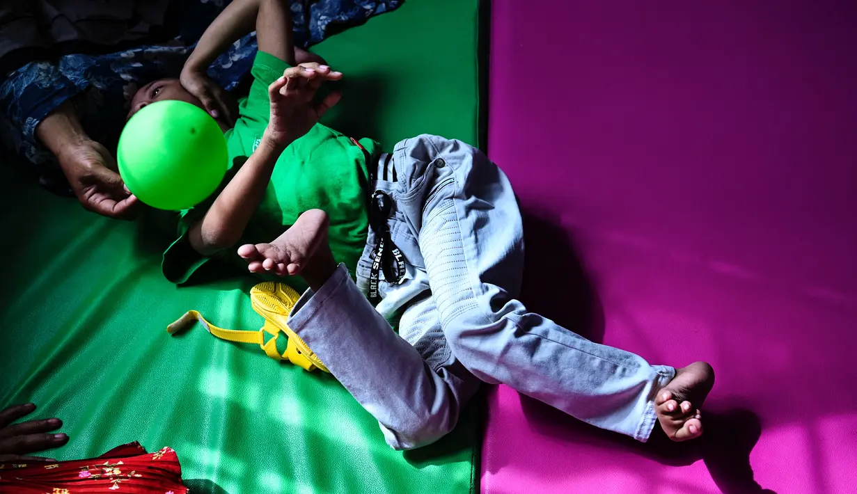 Seorang anak penderita cerebral palsy berbaring di atas matras saat berkumpulnya keluarga untuk memperingati Hari Cerebral Palsy Sedunia di pusat fisioterapi Yayasan Sahabat Difabel di Banda Aceh (6/10/2021). (AFP/Chaideer Mahyuddin)