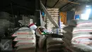 Pekerja beristirahat ditumpukan karung beras di pasar induk Cipinang, Jakarta, Selasa (27/12). Kecukupan kebutuhan tersebut diharapkan bisa menahan laju kenaikan harga barang pokok. (Liputan6.com/Angga Yuniar)