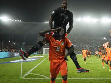 Pemain Pantai Gading, Franck Kessie (bawah) dan kiper Yahia Fofana merayakan kemenangan atas Senegal pada babak 16 besar Piala Afrika 2023 di Stade Charles Konan Banny, Yamoussoukro, Selasa (30/01/2024) dini hari WIB. Pantai Gading menang dengan skor 5-4 pada babak adu penalti. (AP Photo/Themba Hadebe)