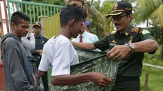 Polisi Syariat Islam memakaikan kain sarung pada warga bercelana pendek saat razia penertiban hukum syariat islam di Banda Aceh, Aceh, Selasa (19/9). Razia digelar sebagai implementasi Qanun Aceh No 11 Tahun 2002. (CHAIDEER MAHYUDDIN/AFP)