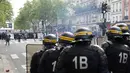Polisi anti huru-hara Prancis menghadapi pengunjuk rasa perayaan May Day di Paris, Senin (1/5). Seorang perwira polisi mengalami luka bakar serius dan dua lainnya luka-luka dalam bentrokan yang melibatkan bom molotov tersebut. (Zakaria ABDELKAFI/AFP)