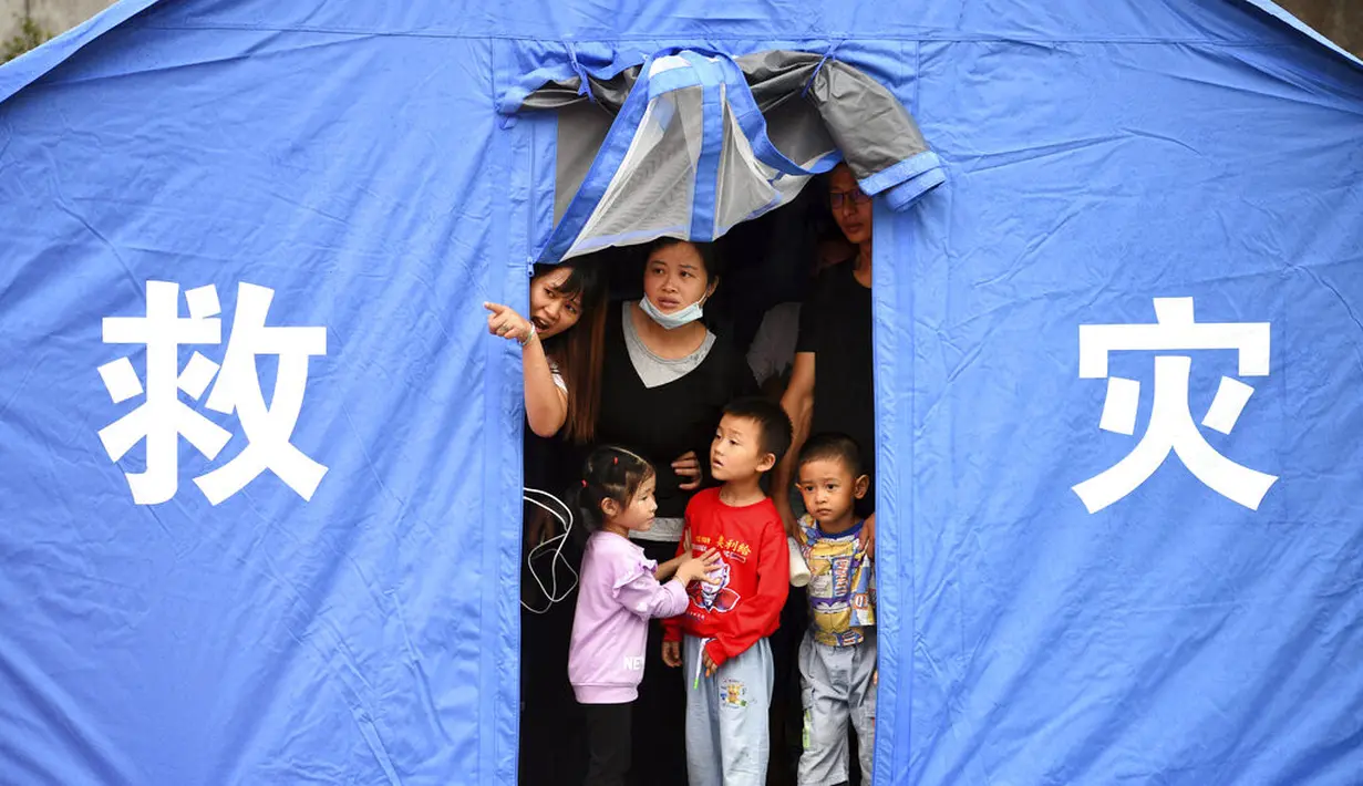 Warga berkumpul di dalam tenda dengan tulisan "Disaster Rescue" setelah gempa bumi magnitudo 4,5  di daerah Luxian di provinsi Sichuan China barat daya, Kamis (16/9/2021). (Chinatopix Via AP)