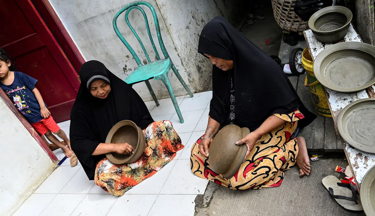 Seorang pembuat tembikar membuat pot tanah liat menggunakan tangan dalam bengkel rumah di Banda Aceh, Aceh, Rabu (4/8/2021). (CHAIDEER MAHYUDDIN/AFP)