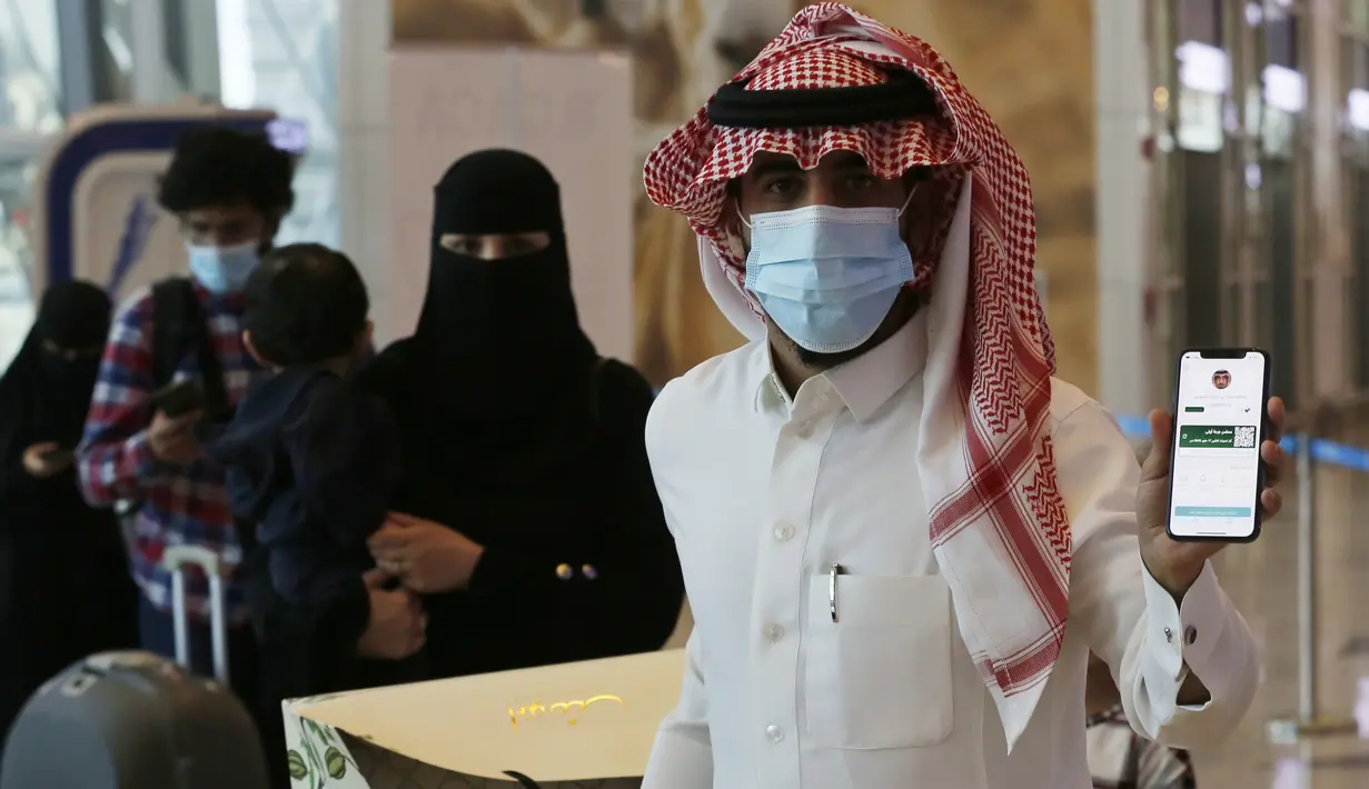 Sultan Saeed Al-Shahrani, menunjukkan sertifikat vaksinasi di ponselnya, di pos pemeriksaan Bandara Internasional King Abdulaziz, Jeddah, Senin (177/5/2021). Warga Saudi yang divaksinasi Covid-19 diizinkan bepergian ke luar negeri menyusul dicabutnya larangan perjalanan. (AP Photo/Amr Nabil)