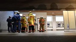 Tim pemadam kebakaran berkumpul di luar Stasiun Kokuryo di Jalur Keio di kota Chofu di Tokyo barat (31/10/2021).  Sang pelaku, kata polisi, berhasil diamankan langsung di tempat kejadian. (AFP/Jiji Press/STR)