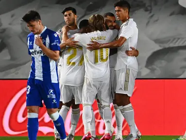 Pemain depan Real Madrid, Karim Benzema (tengah) bersama rekan setimnya merayakan gol ke gawang Alaves pada lanjutan Liga Spanyol di stadion Alfredo di Stefano, Sabtu (11/7/2020). Real Madrid menang 2-0 lewat gol Karim Benzema dan Marco Asensio. (GABRIEL BOUYS/AFP)
