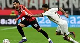 Bek AC Milan, Theo Hernandez (kiri) melewati pemain Lecce, Tete Morente selama pertandingan sepak bola Serie A Italia di stadion San Siro, Milan, pada Jumat 27 September 2024 atau Sabtu (28/9/2024) dini hari WIB. (Gabriel BOUYS/AFP)