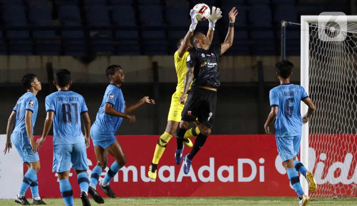 Kiper Persela Lamongan Dwi Kuswanto (tengah) berhasil menangkap bola dalam pertandingan babak penyisihan Grup C Piala Menpora 2021 melawan Madura United di Stadion Si Jalak Harupat, Bandung, Kamis (1/4/2021). Pertandingan berakhir dengan skor 1-1. (Bola.com/Ikhwan Yanuar)
