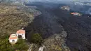 Lava dari letusan gunung Cumbre Vieja mengalir menghancurkan rumah-rumah di pulau La Palma di Canaries, Spanyol, Selasa (21/9/2021). Diketahui gunung berapi ini merupakan salah satu daerah vulkanik paling aktif di Canaries dan pernah mengalami letusan besar pada tahun 1971. (AP/Emilio Morenatti)