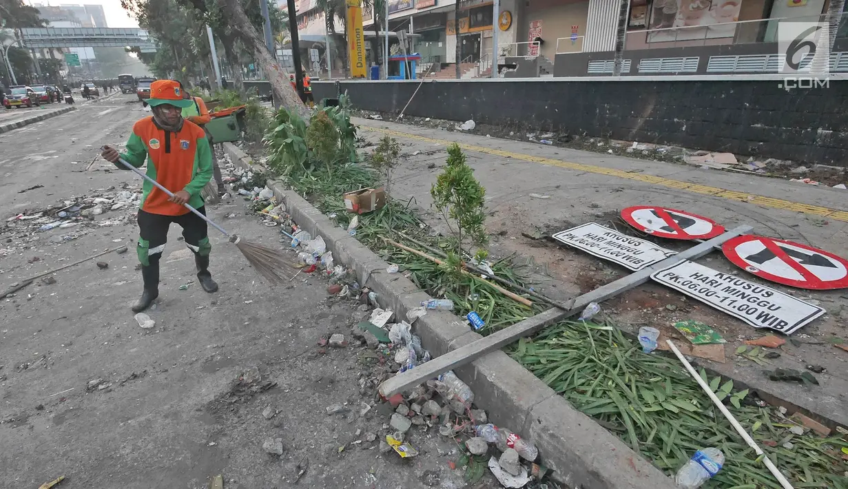 Petugas Penanganan Prasarana dan Sarana Umum (PPSU) atau Pasukan Oranye membersihkan sisa puing-puing pasca kerusuhan di kawasan Wahid Hasyim, Jakarta, Kamis (23/5/2019). Kerusuhan massa yang sebelumnya berdemo di depan gedung Bawaslu melebar ke Jalan Wahid Hasyim. (Liputan6.com/Herman Zakharia)