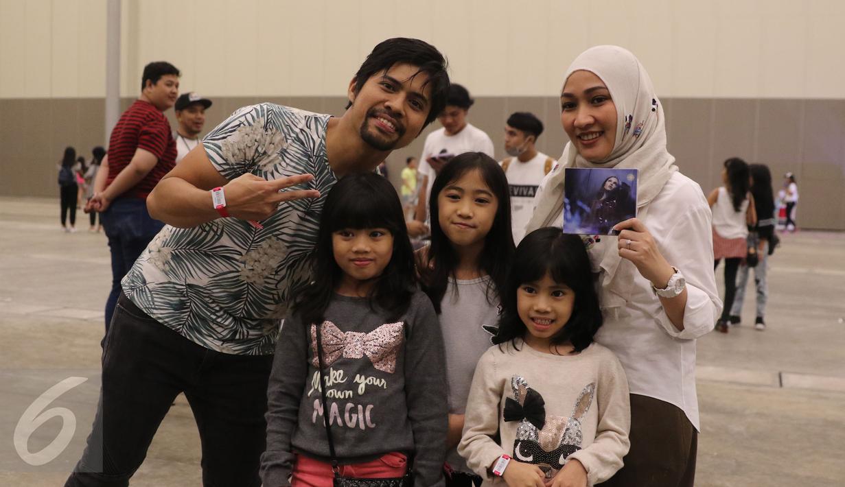 Drummer band Gigi, Gusti Hendy bersama istri dan anaknya saat menonton konser pertama penyanyi Selena Gomez di Indonesia yang digelar di Indonesia Convention Exhibition (ICE) BSD, Tangerang Selatan, Sabtu (23/7). (Liputan6.com/Herman Zakharia)