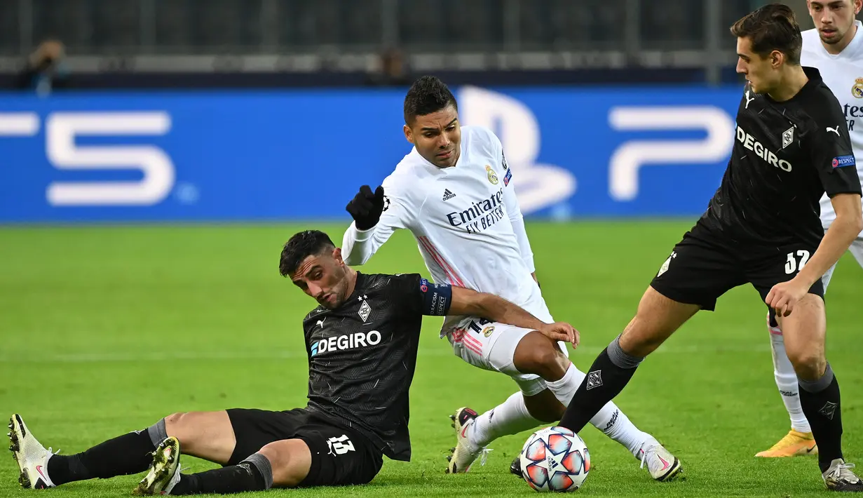 Gelandang Real Madrid, Casemiro, berebut bola dengan gelandang Borussia Monchengladbach, Lars Stindl, pada laga lanjutan Liga Champions di Borussia Park, Rabu (28/10/2020) dini hari WIB. Real Madrid bermain imbang 2-2 lawan Borussia Monchengladbach. (AFP/(AFP/Ina Fassbender)