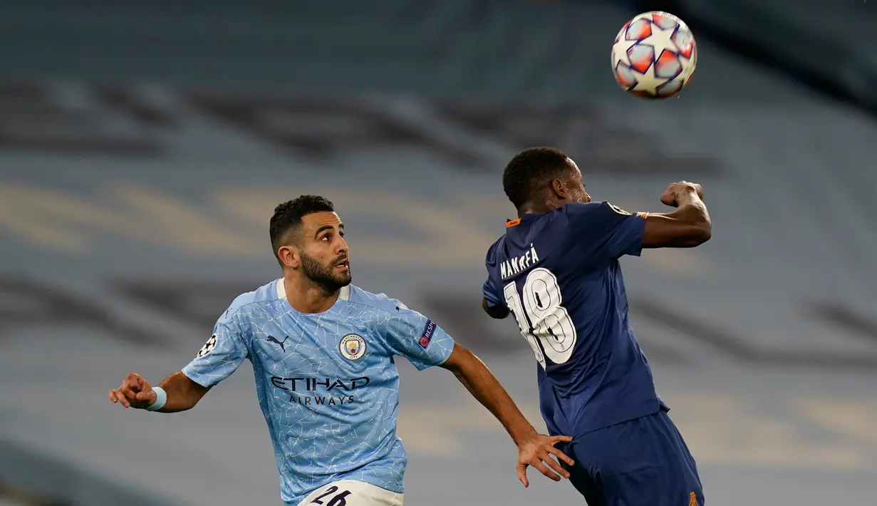 Penyerang Manchester City, Riyad Mahrez berebut bola dengan pemain FC Porto, Wilson Manafa pada matchday pertama Grup C Liga Champions di Etihad Stadium, Kamis (22/10/2020) dini hari WIB. Manchester City sukses menaklukan Porto dengan skor 3-1. (Tim Keeton/Pool via AP)