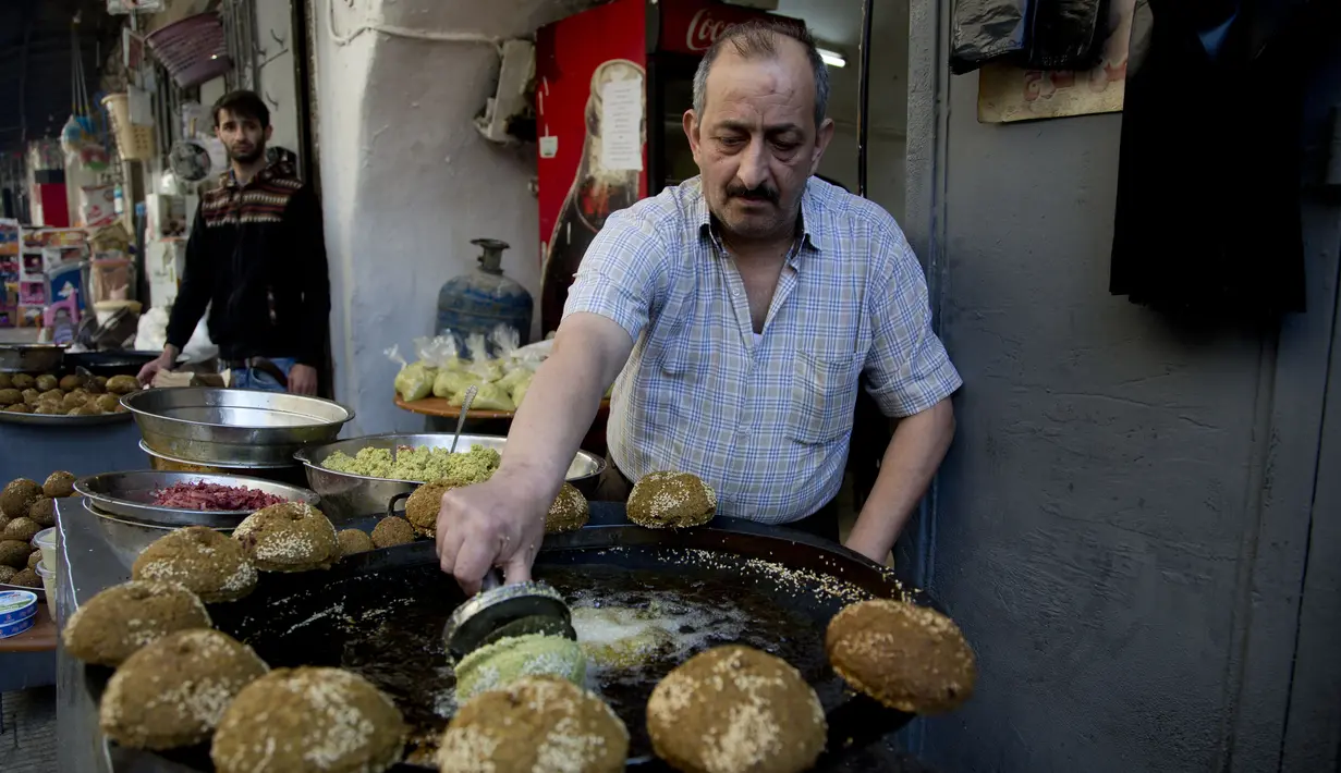 Pedagang membuat kudapan Falafel untuk menu berbuka puasa selama Ramadan di Kota Nablus, Tepi Barat, Minggu (26/4/2020). (AP Photo/Majdi Mohammed)