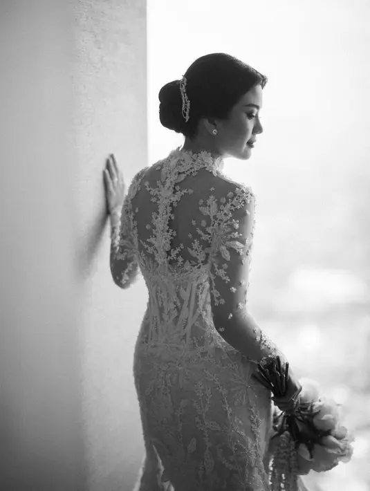 Kebaya warna putih tersebut memiliki potongan kerah tegak yang klasik. Serta bustier transparan yang memperlihatkan garis-garis pada bodice. [Foto: @mordenco]