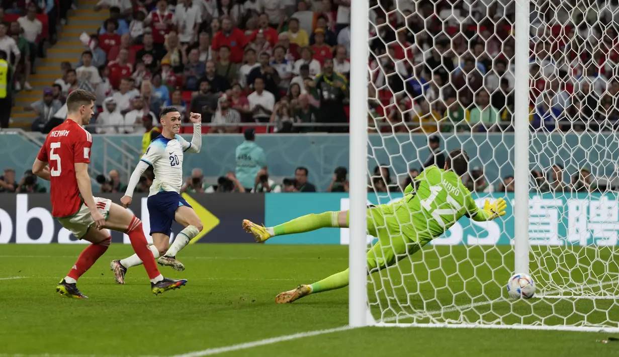 <p>Pemain Inggris, Phil Foden mencetak gol kedua timnya ke gawang Wales saat matchday ketiga Grup B Piala Dunia 2022 di Ahmad Bin Ali Stadium, Rabu (30/11/2022). (AP/Frank Augstein)</p>