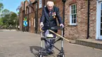 Veteran Perang Dunia II Kapten Tom Moore (99) berjalan di kebunnya di Marston Moretaine, London, 16 April 2020. Moore mengumpulkan donasi lebih dari 16 juta dolar untuk National Health Service (NHS) dengan berjalan 100 kali bolak-balik jarak 25 meter di taman belakang rumahnya. (Justin TALLIS/AFP)