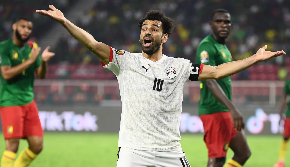 Reaksi kecewa striker Timnas Mesir, Mohamed Salah terhadap keputusan wasit saat menghadapi Kamerun pada laga semifinal Piala Afrika 2021 di Stade d'Olembe, Yaounde (3/2/2022). Mohamed Salah telah membela Liverpool sejak awal musim 2017/2018. Bersama Timnas Mesir ia kini menjabat sebagai kapten utama The Paraoh sejak 2021 menggantikan Ahmed Elmohamady. (AFP/Charly Triballeau)