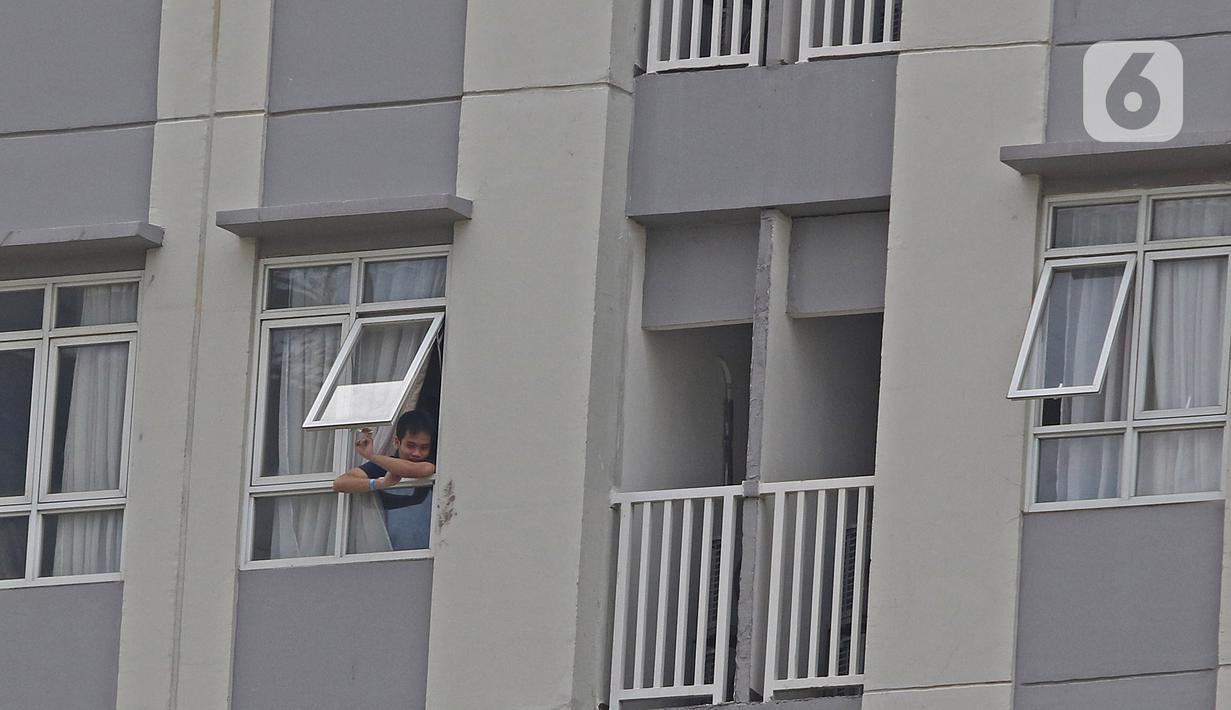 Pasien berstatus OTG (Orang Tanpa Gejala) berdiri di jendela Rumah Sakit Darurat Wisma Atlet Kemayoran, Jakarta, Selasa (26/1/2021). Hari ini, Selasa (26/1) kasus COVID-19 di Indonesia bertambah 13.094 sehingga total menyentuh angka satu juta, tepatnya 1.012.350. (Liputan6.com/Herman Zakharia)