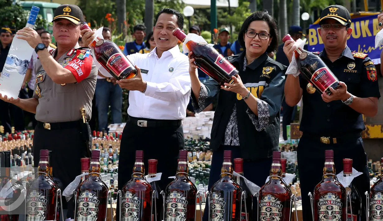 Menkeu Sri Mulyani bersama Kepala BNN, Komjen Budi Waseso, Dirjen Bea dan Cukai Heru Pambudi dan Kapolda Metro Jaya Irjen M Iriawan saat pemusnahan miras dan rokok ilegal di Kantor Bea cukai, Jakarta, Jumat (23/12). (Liputan6.com/Johan Tallo)