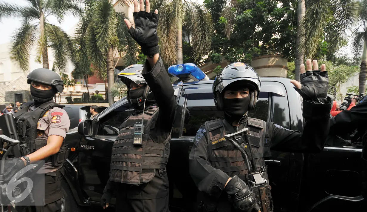 Anggota Brimob menjaga ketat mobil yang mengangkut tersangka perampokan disertai penyanderaan di Kawasan Pondok Indah, Jakarta, Minggu (3/9). Dua tersangka pelaku berhasil dilumpuhkan polisi. (Liputan6.com/Helmi Fithriansyah)