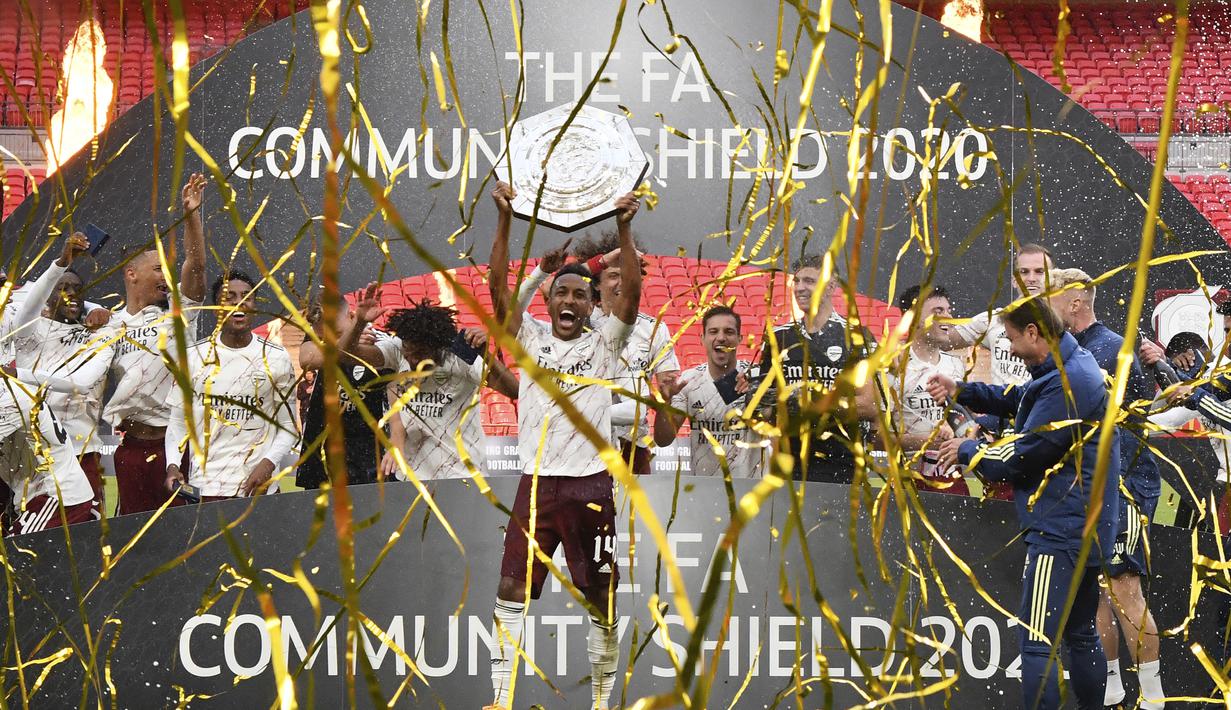 Pemain Arsenal, Pierre-Emerick Aubame, mengangkat trofi Community Shield 2020 usai mengalahkan Liverpool di Stadion Wembley, Sabtu (29/8/2020) malam WIB. Arsenal menang 5-4 atas Liverpool lewat adu penalti. (Justin Tallis/Pool via AP)