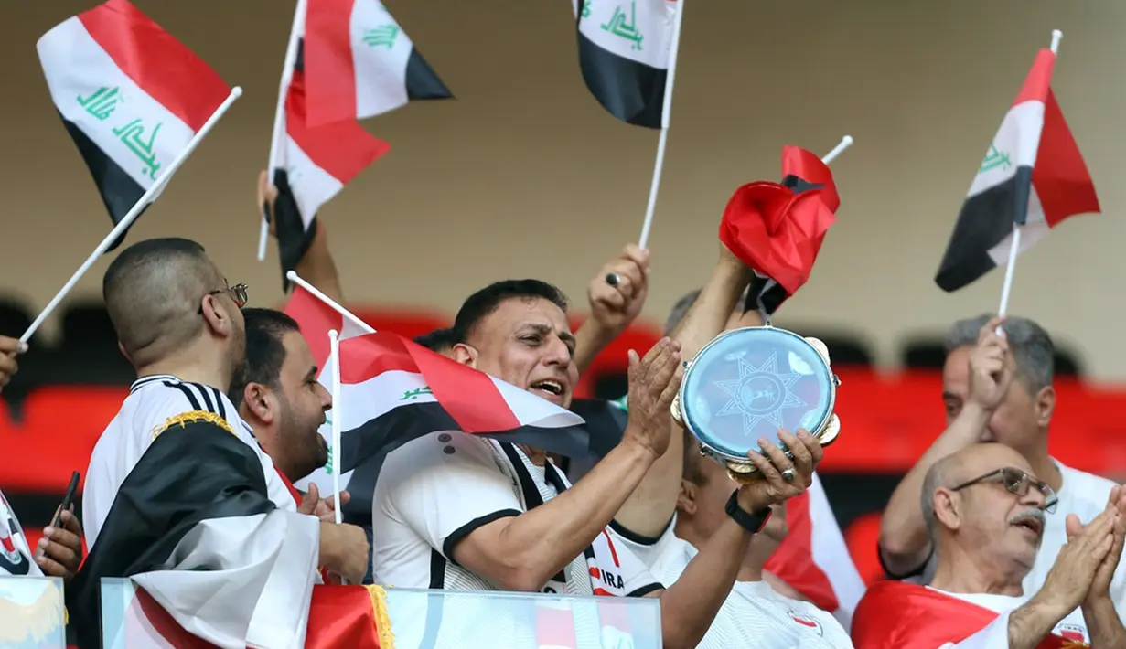 Suporter Irak mengibarkan bendera nasional menjelang pertandingan sepak bola Grup D Piala Asia antara Indonesia dan Irak di Stadion Ahmad Bin Ali, Al Rayyan, Qatar, Senin (15/1/2024). (AP Photo/Hussein Sayed)
