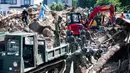 Tim penyelamat dan tentara membersihkan puing-puing yang berserakan usai banjir melanda Kumano, Prefektur Hiroshima, Jepang, Senin (9/7). Prefektur Hiroshima menjadi kawasan yang terdampak paling parah. (Martin BUREAU/AFP)