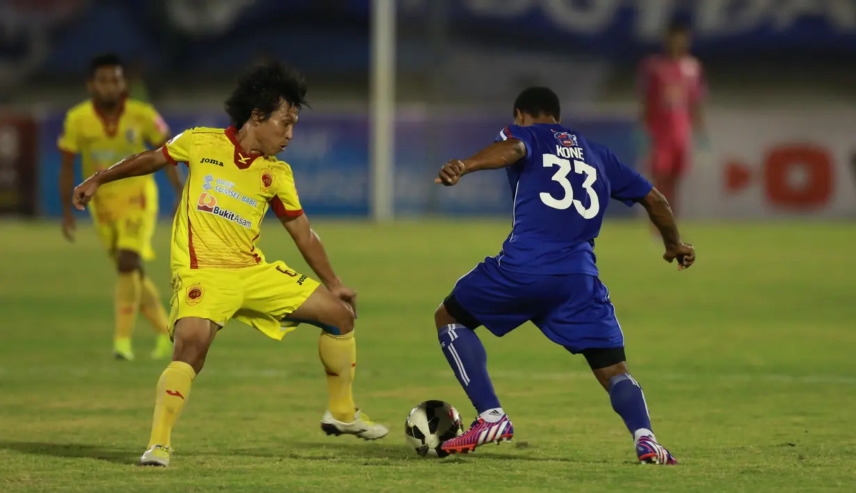 Pemain Sriwijaya FC Asri Akbar (kiri) berebut bola dengan pemain Arema Cronus Lancine Kone  pada laga semifinal Piala Presiden di Stadion Manahan, Solo, Minggu (11/10/2015). Sriwijaya menang 2-1. (Bola.com/Nicklas Hanoatubun).