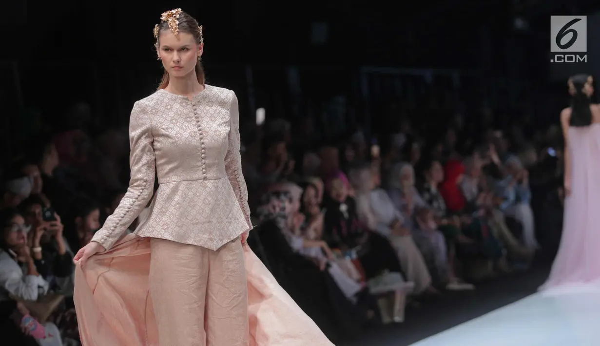 Model berpose membawakan busana rancangan Barli Asmara di ajang Jakarta Fashion Week 2018 di Senayan City, Jakarta, Senin (23/10). Desainer Barli Asmara merancang 48 busana dengan tema Jambi Kain Negeriku. (Liputan6.com/Faizal Fanani)