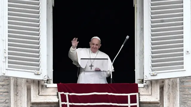 Paus Fransiskus melambaikan tangan saat memimpin Doa Angelus dari jendela studionya yang menghadap Lapangan Santo Petrus di Vatikan, Minggu (1/3/2020). Pemimpin umat Katolik itu untuk pertama kalinya tampil di muka publik dalam empat hari terakhir setelah tak enak badan. (Filippo MONTEFORTE/AFP)