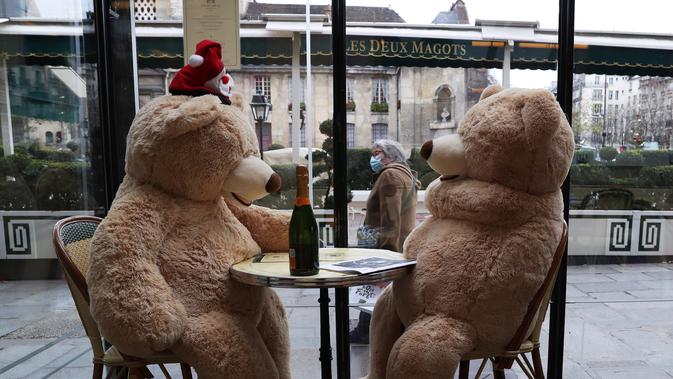 Sepasang boneka beruang raksasa terlihat di kafe Les Deux Magots yang ditutup di Paris, Prancis pada 16 Desember 2020. Otoritas kesehatan Prancis pada Rabu (16/12) melaporkan 17.615 kasus infeksi COVID-19 tambahan dalam 24 jam terakhir, penambahan harian terbesar sejak 21 November. (Xinhua/Gao Jing)