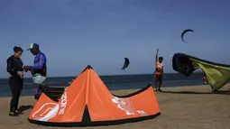 Seorang peserta Kitesurfing tengah bersiap bersama instruktur saat mengikuti ajang Third Kite Addict Kolombia tournamen di Cabo de la Vela, Guajira Departmen, Kolombia, (4/7/2016). (AFP/Joaquin Sarmiento)