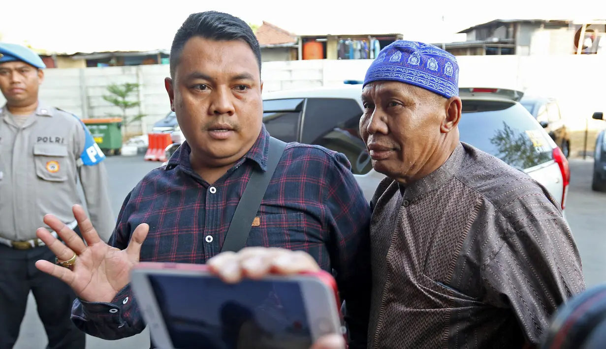 Abah Grandong pemakan kucing didampingi kerabat tiba di Polres Jakarta Pusat, Kamis (1/8/2019). Abah Grandong menyerahkan diri ke Polres dan akan menjalani pemeriksaan terkait video memakan kucing hidup-hidup yang viral di media sosial. (Liputan6.com/Herman Zakharia)