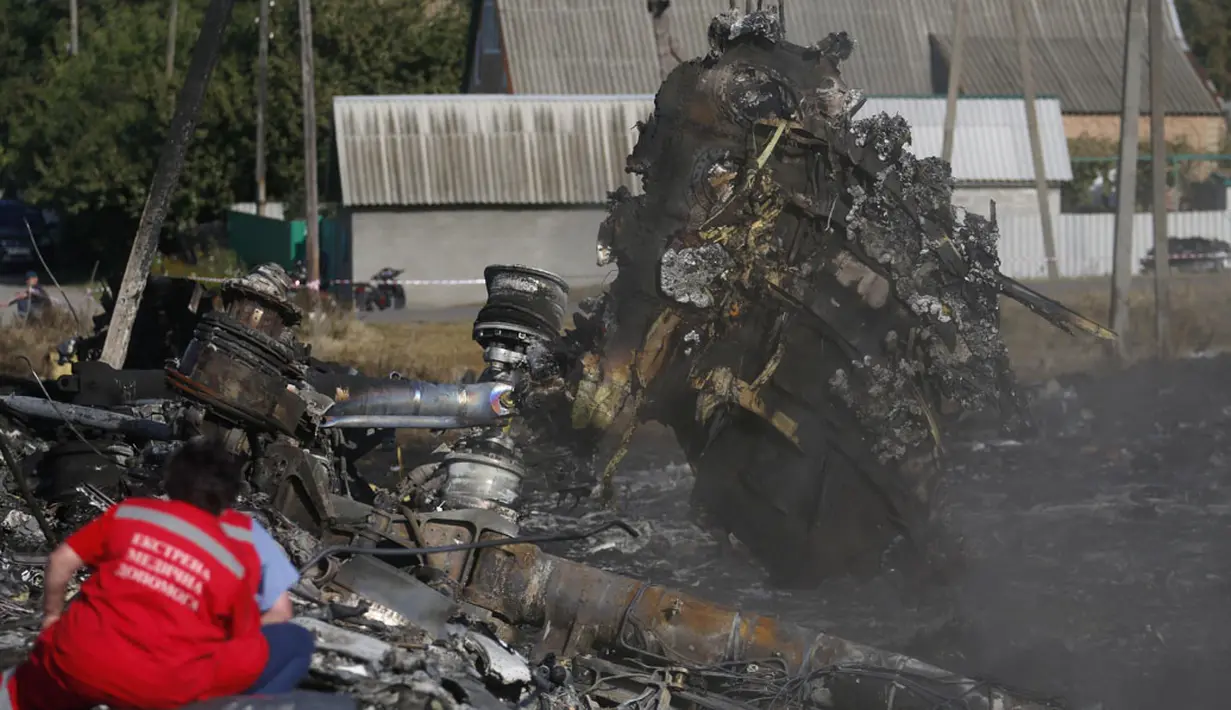 Salah satu pekerja mengawasi proses pengangkatan puing pesawat Malaysia Airlines MH-17 yang jatuh di desa Hrabove, Donetsk, Ukraina, (20/7/2014). (REUTERS/Maxim Zmeyev) 