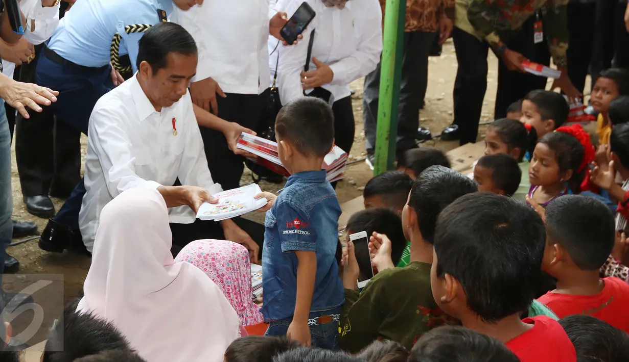 Presiden Joko Widodo (Jokowi) membagi-bagikan buku tulis untuk anak-anak saat meninjau tenda pengungsian korban gempa Aceh di Pidie Jaya, Jumat (9/12). Selain buku tulis, Jokowi juga membagikan kotak pensil kepada warga. (Liputan6.com/Angga Yuniar)
