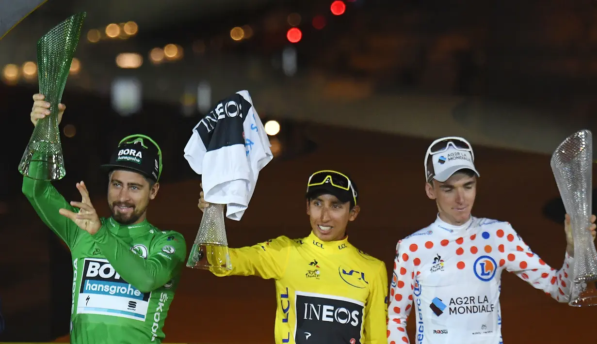 Pebalap Kolombia Egan Bernal (tengah) bersama Peter Sagan (kiri) dan Romain Bardet mengangkat piala saat memenangkan Tour de France 2019, Paris, Prancis, Minggu (28/7/2019 ). Egan menjuarai Tour de France 2019 setelah berjuang dalam marathon tiga minggu. (Stephane Mantey, Pool Photo via AP)