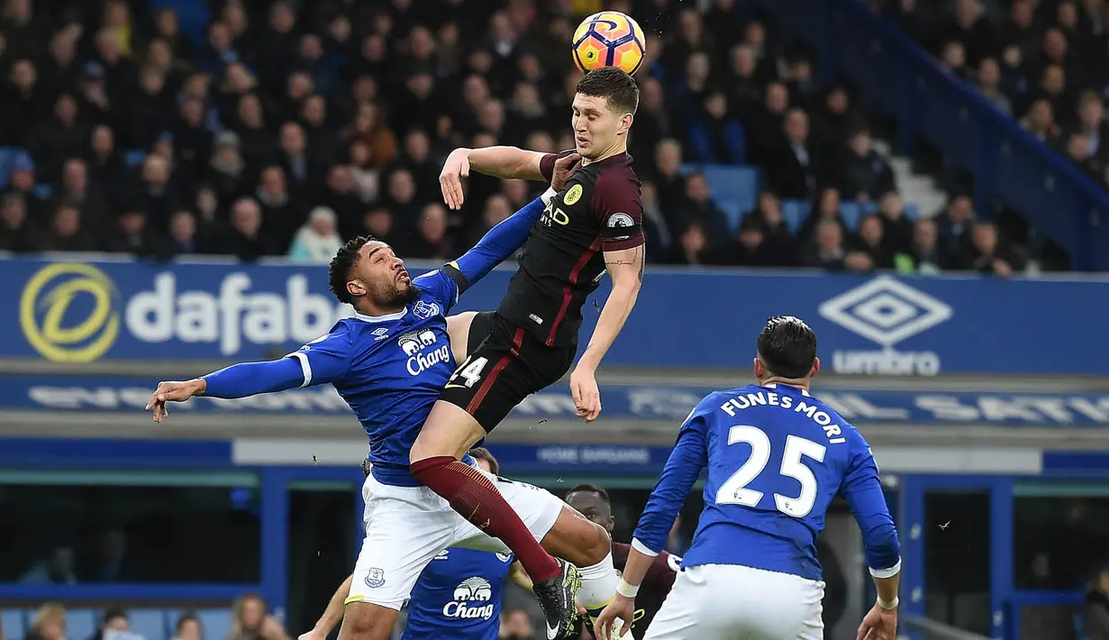 Bek Manchester City, John Stones, duel udara dengan bek Everton, Ashley Williams. Kendati menang 4-0, Everton bermain bertahan dan City lebih sering menyerang namun gagal mencetak gol. (AFP/Paul Ellis)