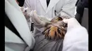 Dokter hewan menyuntikkan cairan nutrisi untuk burung hantu elang lewat mulutnya di sebuah rumah sakit hewan Shenyang, Liaoning,  Rabu (21/1/2015). Burung hantu jenis ini merupakan salah satu hewan yang dilindungi di Tiongkok (REUTERS/Stringer)