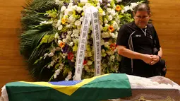 Seorang pelayat yang memberi penghormatan didekat jenazah mantan pemain sepak bola Brasil, Carlos Alberto yang sedang disemayamkan di di Konfederasi Sepakbola Brasil (CBF) di Rio de Janeiro, Brasil (25/10). (Reuters/ Ricardo Moraes)